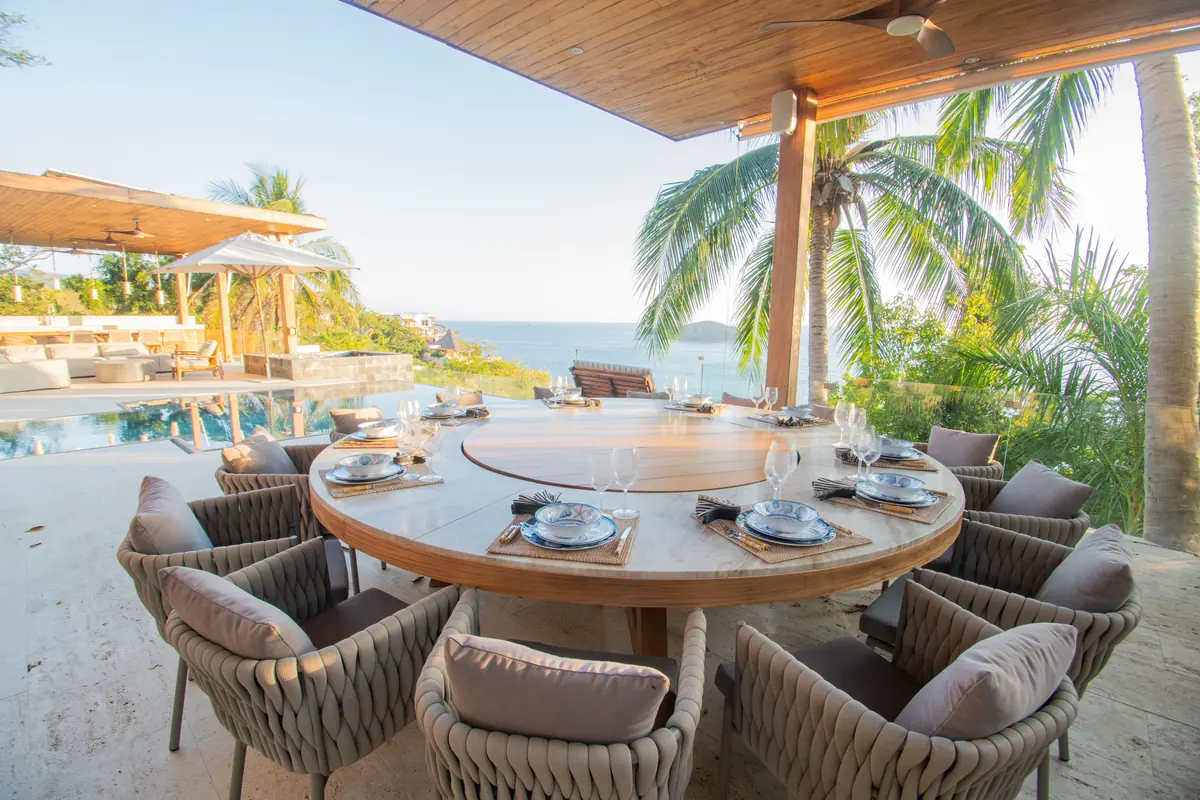 Una mesa preparada en una terraza con vista al Pacífico